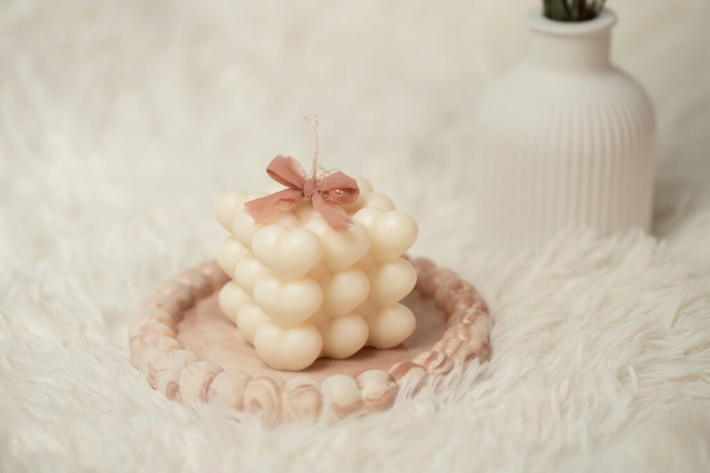 A white vase sitting on top of a white fur covered floor